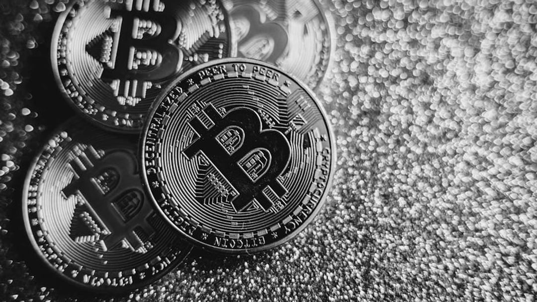 Close-up of Bitcoin cryptocurrency coins on a sparkling gold glitter background, symbolizing digital finance, illustrating
