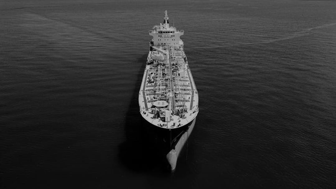 Aerial shot of an oil tanker on the ocean at sunset in Galveston, Texas — context for gold price Iran war (energy bills