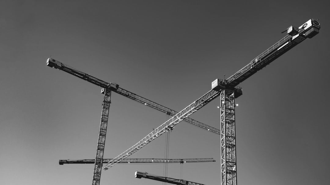 Construction cranes against a clear blue sky — context for Taylor Wimpey shares (inflation angle)