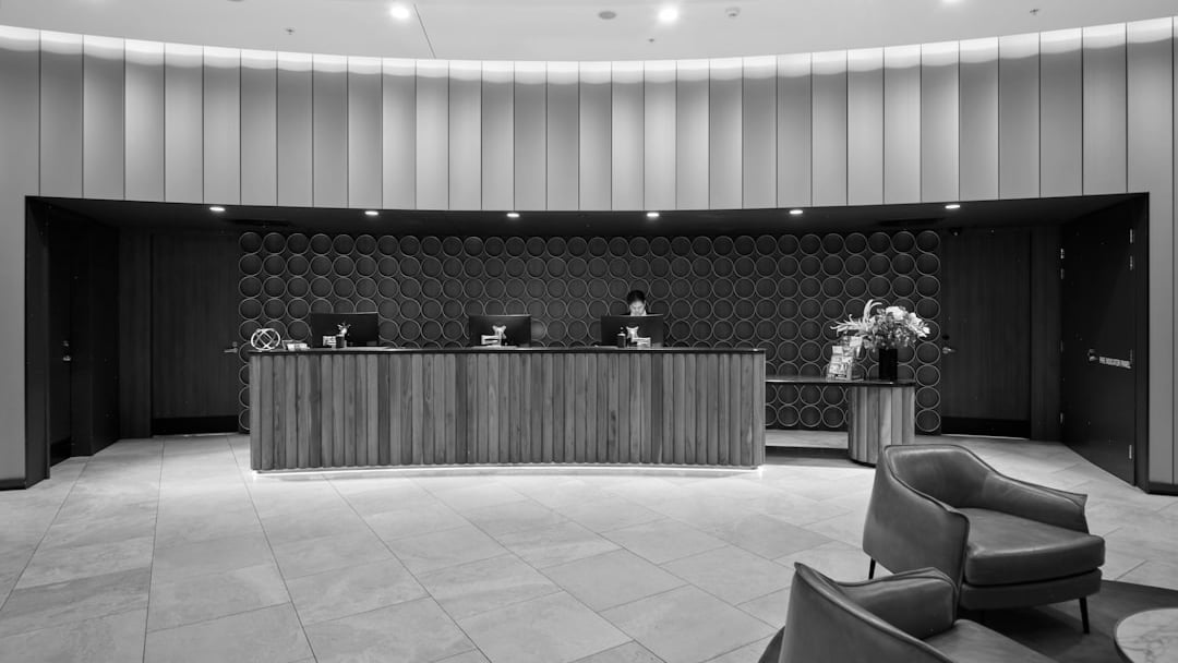 Hotel reception desk with modern wooden furniture and seating (Whitbread), context for Whitbread share price uk