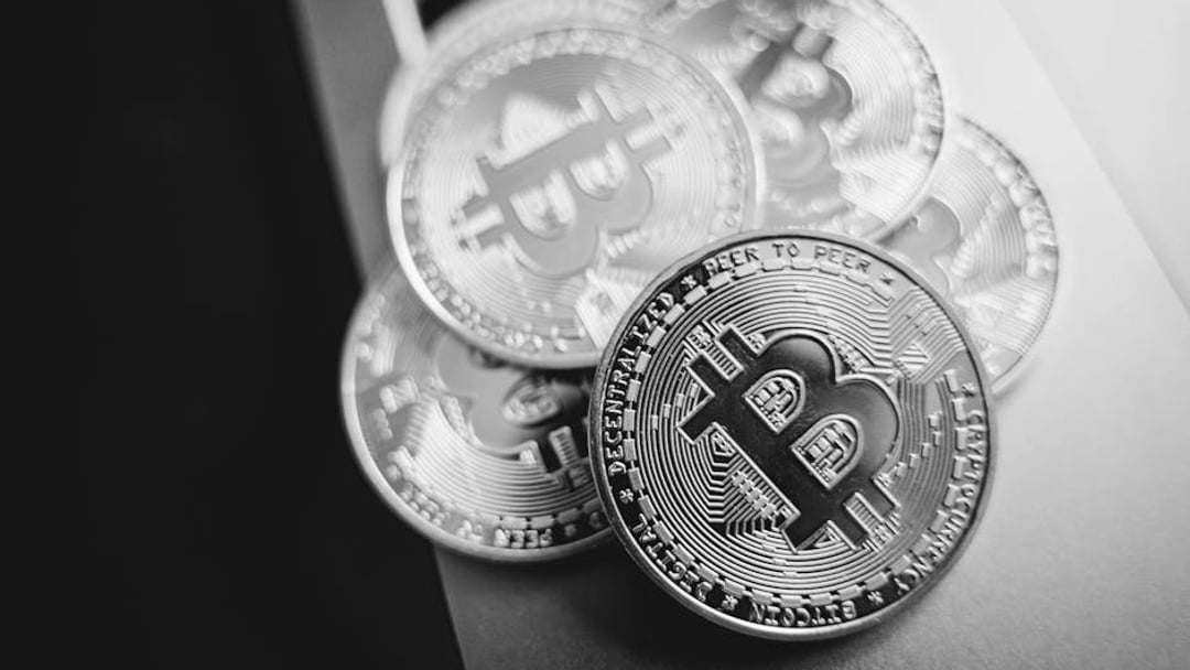 Close-up of golden Bitcoin coins on a laptop keyboard, symbolizing cryptocurrency investment, illustrating Bitcoin price