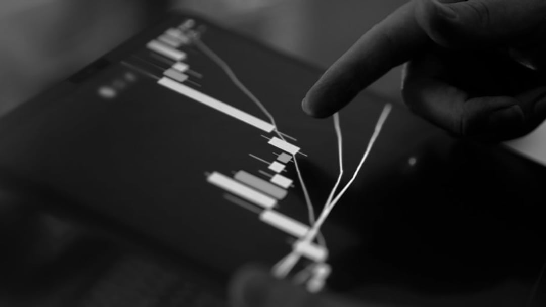 Fingers interacting with a stock market graph on a tablet, illustrating Bitcoin price target
