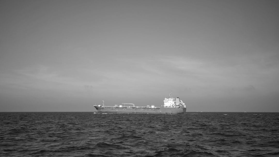 A red tanker ship sails across the ocean, illustrating Brent oil price