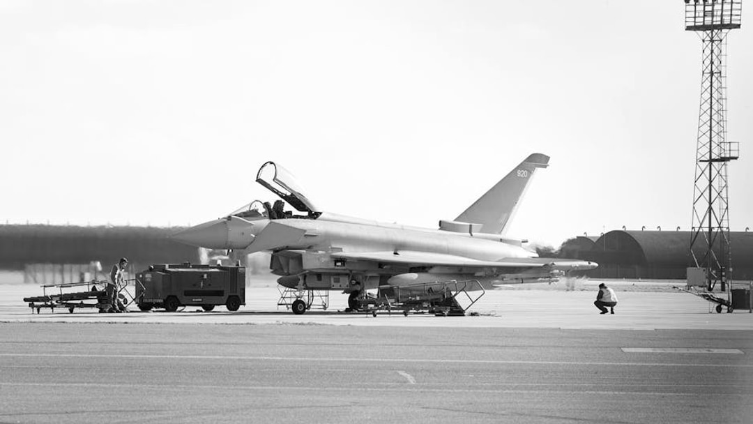 Eurofighter Typhoon jet on airbase tarmac with personnel in England. Military aviation scene, illustrating FTSE 100 dividend