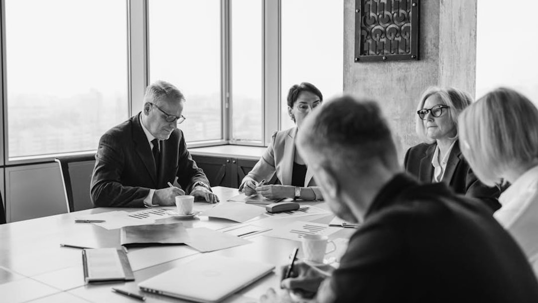 Business professionals engaged in a collaborative meeting around a conference table, illustrating Intertek share price