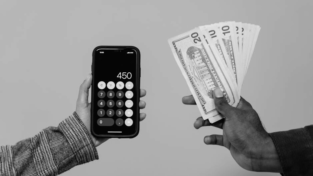 Two hands displaying cash and a smartphone calculator with a digital display, indicating a financial transaction