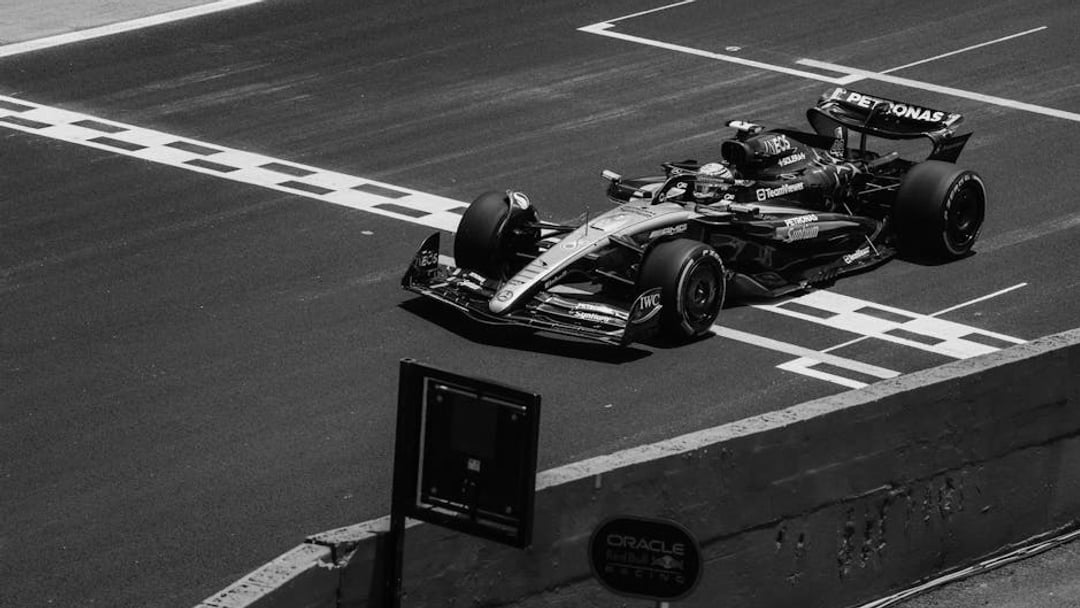 High-speed Formula 1 car crossing the finish line on a race track during the day, illustrating Mercedes Alpine F1 bid