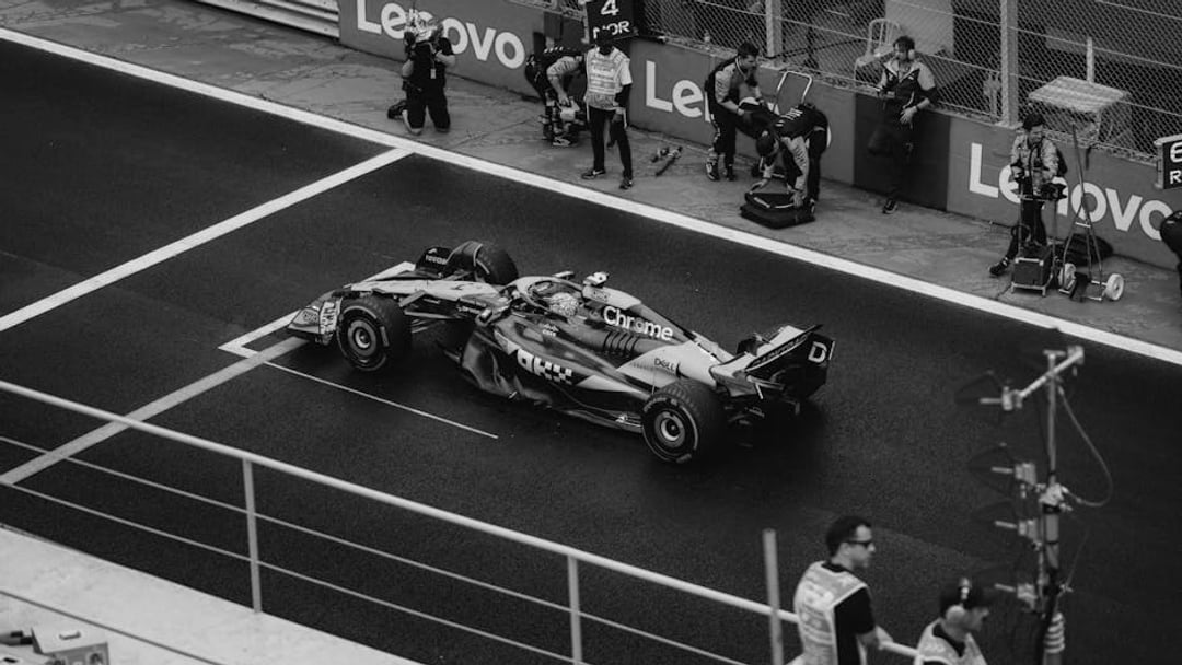 Formula 1 race car in pit stop with crew, showcasing teamwork and speed, illustrating Sky Sports F1 deal