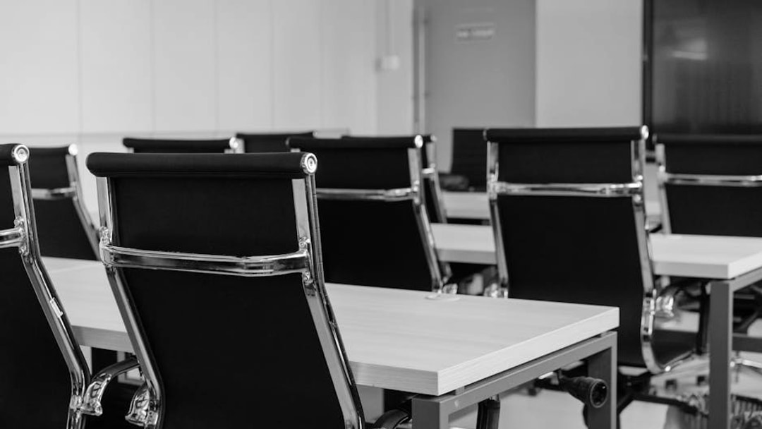 Sleek modern conference room with black chairs and white desks, suitable for business meetings, illustrating UK permanent