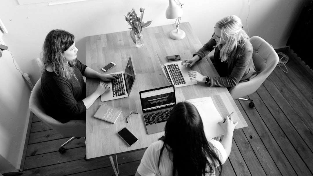 three women sitting and facing each other, illustrating UK permanent jobs