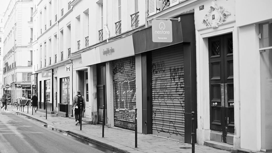 A street scene with closed shops and a person walking, illustrating UK pub closures business rates