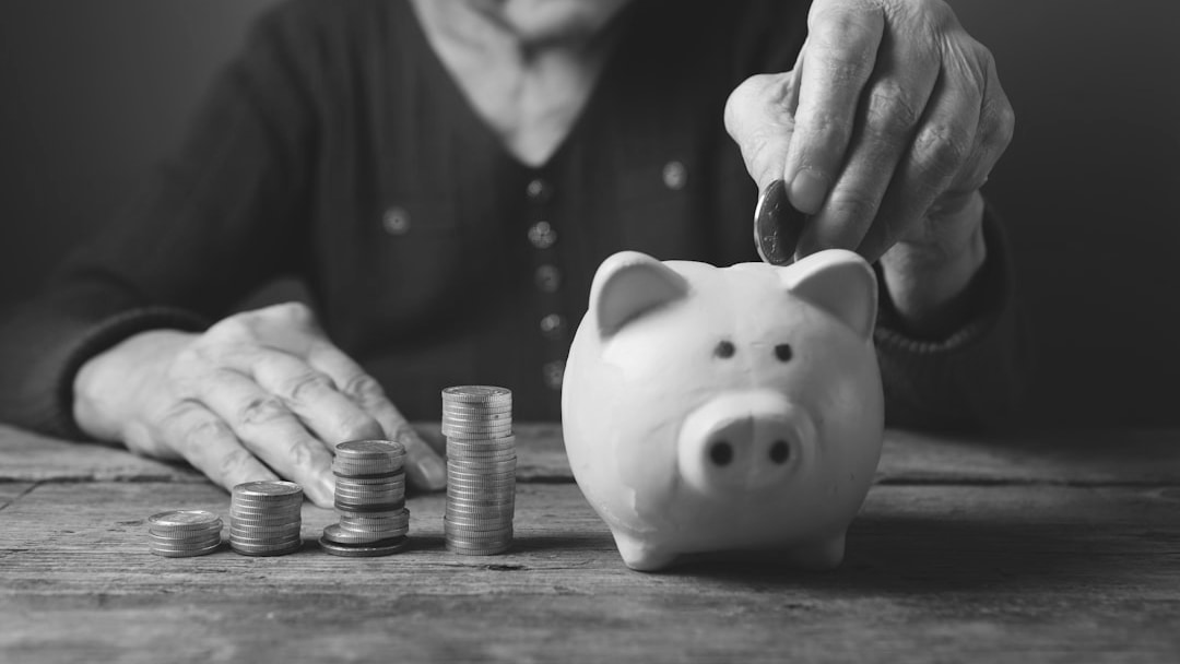 Elderly hands depositing coins into a yellow piggy bank, illustrating UK State Pension G7
