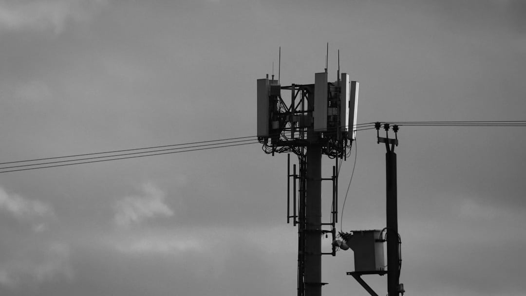 Cell tower against a colorful sunset sky, illustrating Vodafone Three buyout